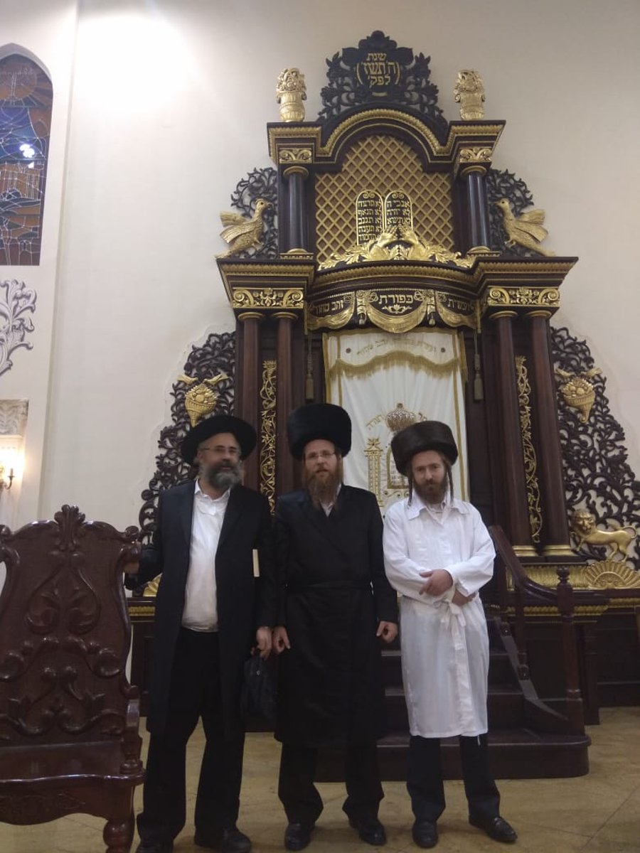 על רקע ארון הקודש של בית הכנסת 'פודול'