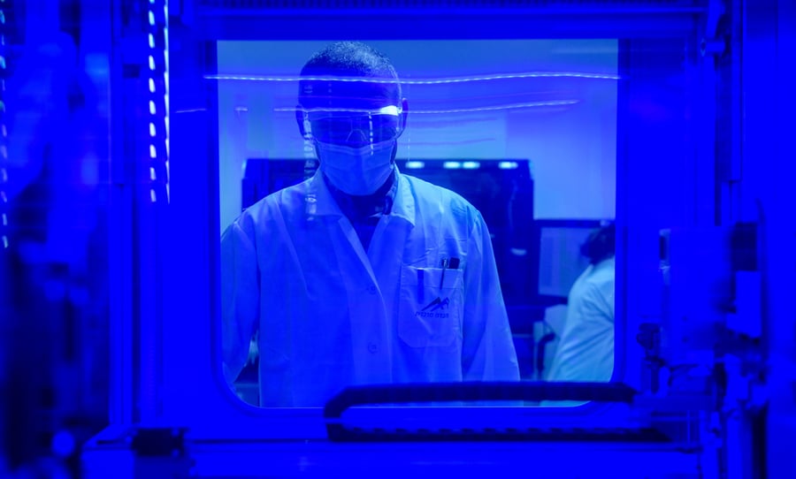 טכנאים מבצעים בדיקת קורונה במעבדה