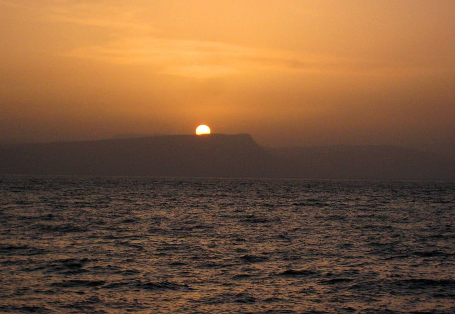שקיעת השמש על אגם הכנרת. ברקע, הר הארבל