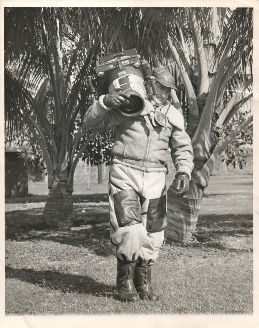 1942, ארה"ב: צלם צבאי מהחטיבה ה-7 של חיל האוויר האמריקני במדינת הוואי, סוחב מצלמת אוויר המיועדת להתקנה על מטוסים