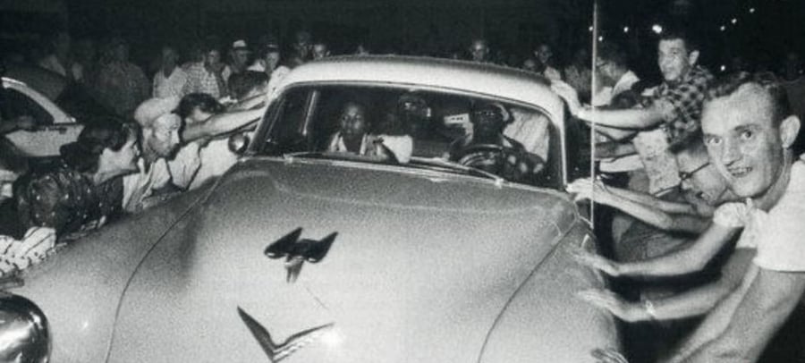 קהל מנסה להפוך מכונית שבתוכו משפחה שחורה. קלינטון, טנסי, 1956