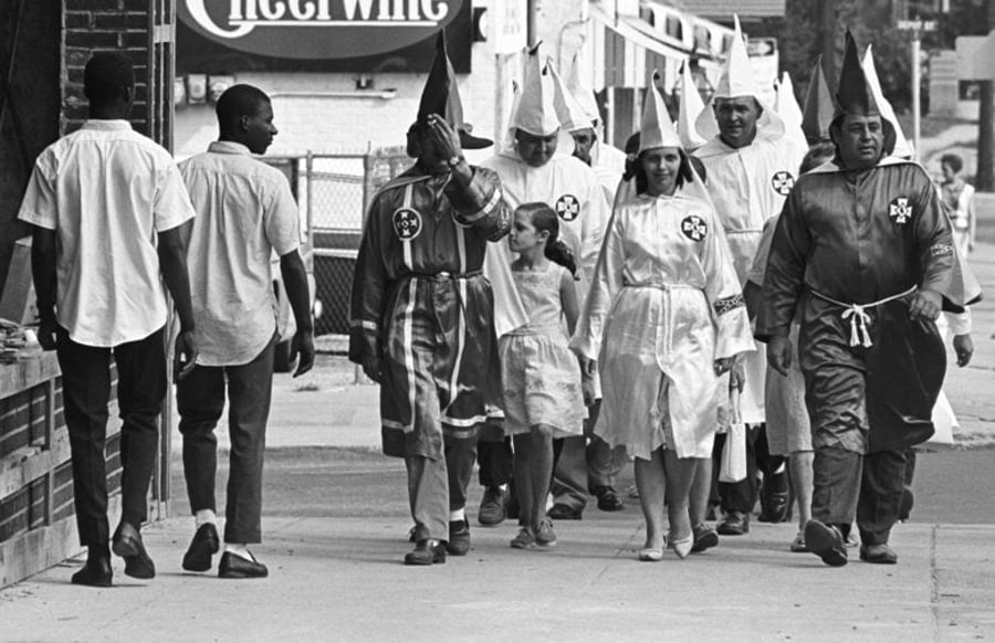 אנשים שחורים חולפים על פני פעילי KKK - אויביהם המרים. 1964