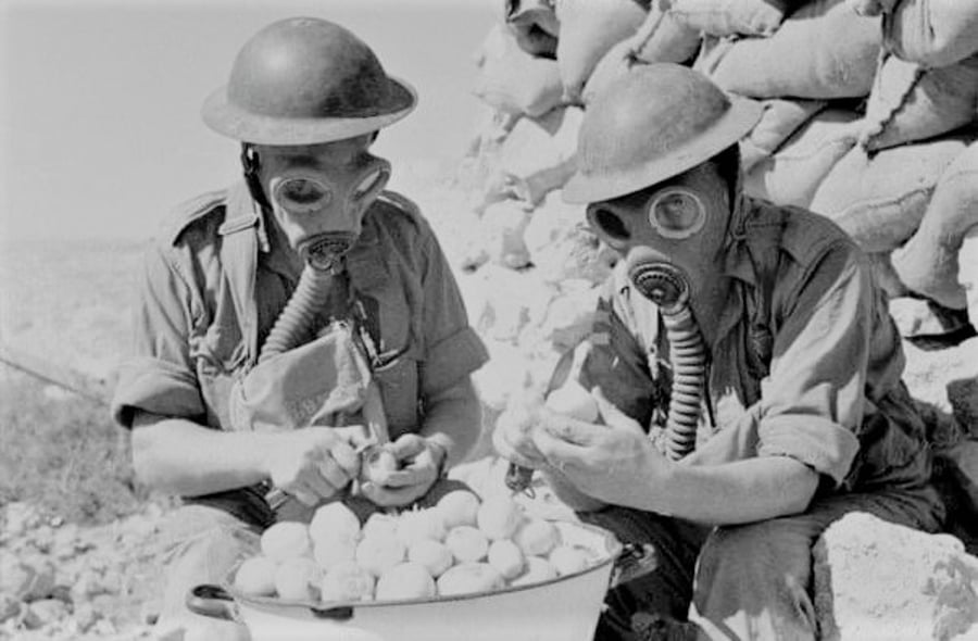 חיילים בריטיים מקלפים בצלים כשהם חובשים מסכות גז. לוב 1941