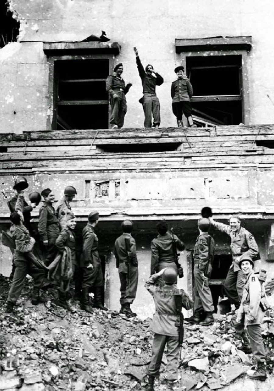 חיילים מבעלות הברית מחקים בלעג את היטלר, כשהם ממוקמים על מרפסת לשכתו שאותה פוצצו. גרמניה 1945