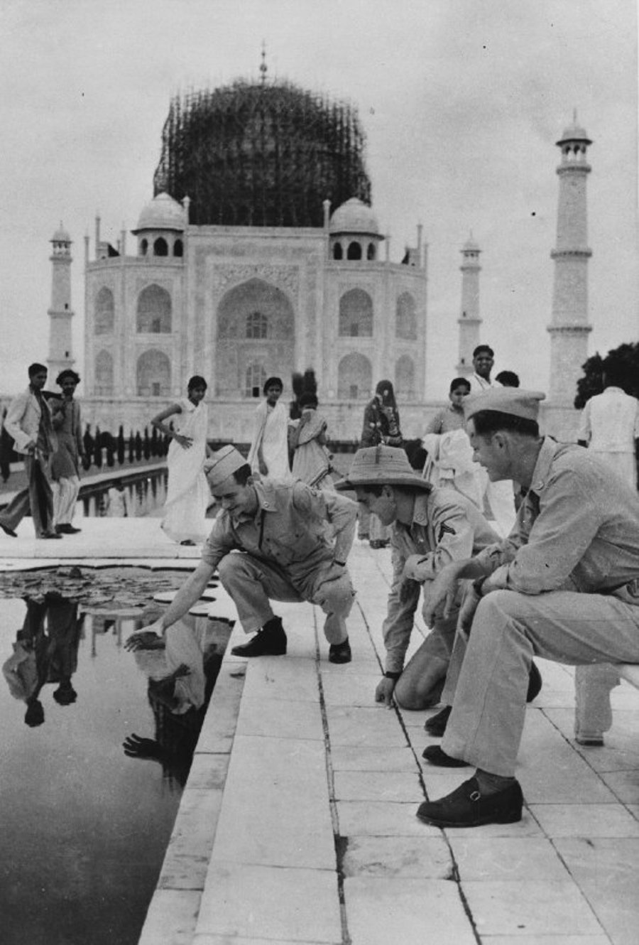 חייל אמריקני מנסה לשלות דג זהב מתוך הבריכה שלמרגלות ארמון הטאג' מאהל. הודו 1942