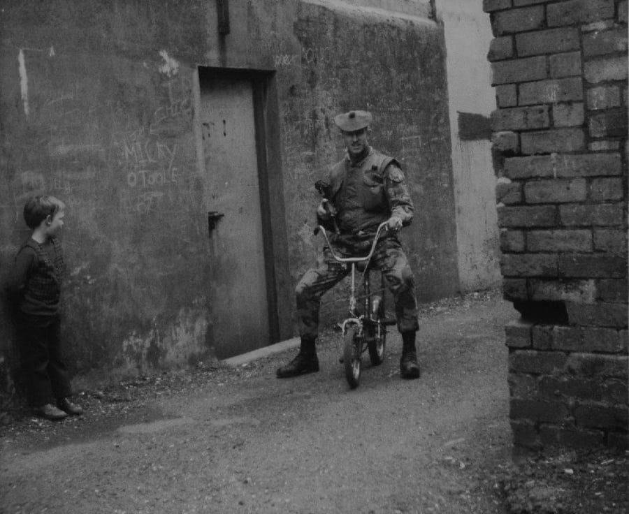 חייל בריטי חוגג על אופני ילדים בעיר בלפסט שבאירלנד. בריטניה 1970