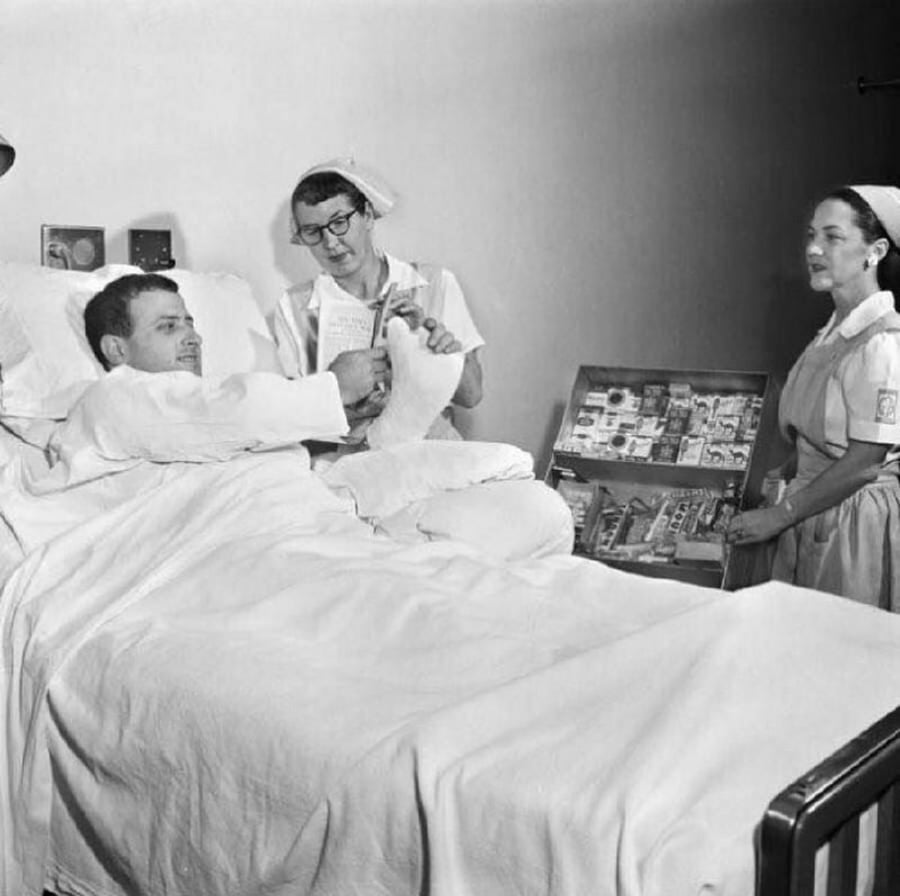 סיגריות היו מצרך בסיסי בבתי חולים. כאן נראות אחיות מתנדבות, מציעות סיגריות למאושפז במיטת חוליו. שנות ה-1950