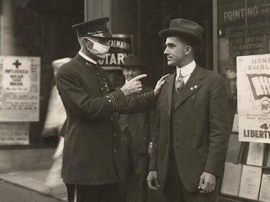 תקופת השפעת הספרדית לפני מאה שנים: שוטר מוכיח אזרח על שאינו עוטה מסכה. סן פרנסיסקו קליפורניה ארה"ב 1918
