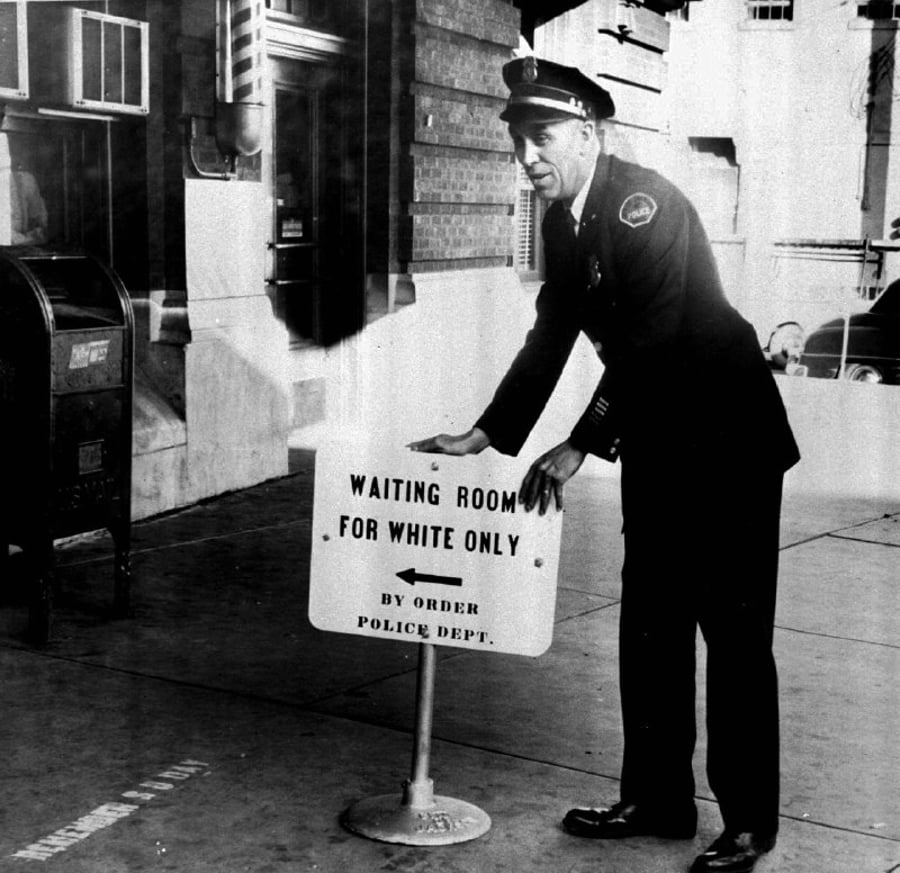 תקופת ההפרדה הגזענית האמריקנית; שוטר מציב שלט: "חדר המתנה ללבנים בלבד, בפקודת תחנת המשטרה". תחנת רכבת מרכזית, שיקגו אילינוי ארה"ב 1956
