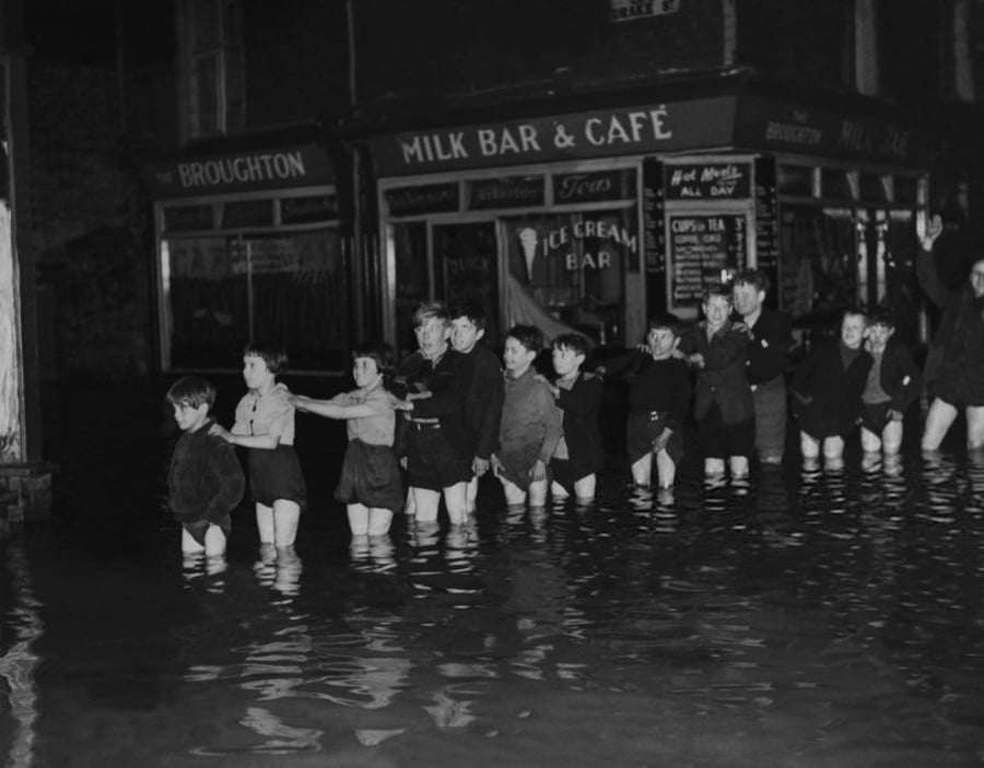 קבוצת ילדים מצטלמת באושר בזמן הצפות של נהר אירוול. לנקשייר אנגליה 1946