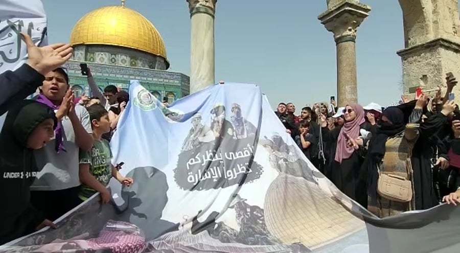 תומכי חמאס מניפים שלט אהדה לארגון הטרור, וקוראים: "אנחנו אנשיך יא חמאס"