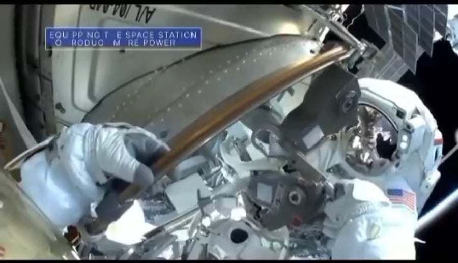 הליכת חלל וכדור הארץ ברקע.