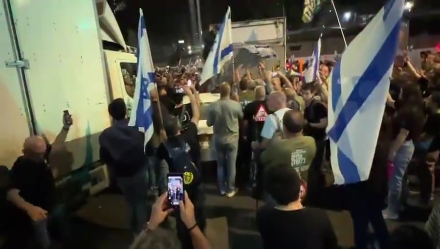 פעילים עם חולצות של "אחים לנשק" מנערים ניידת בהפגנה בתל אביב אמש - מוצאי שבת