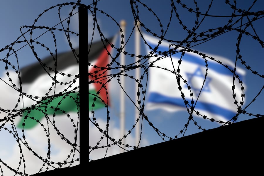 מי ישלטו בקן הצרעות? | דגל פלסטין ודגל ישראל ברקע גדר המערכת בגבות ישראל עם רצועת עזה