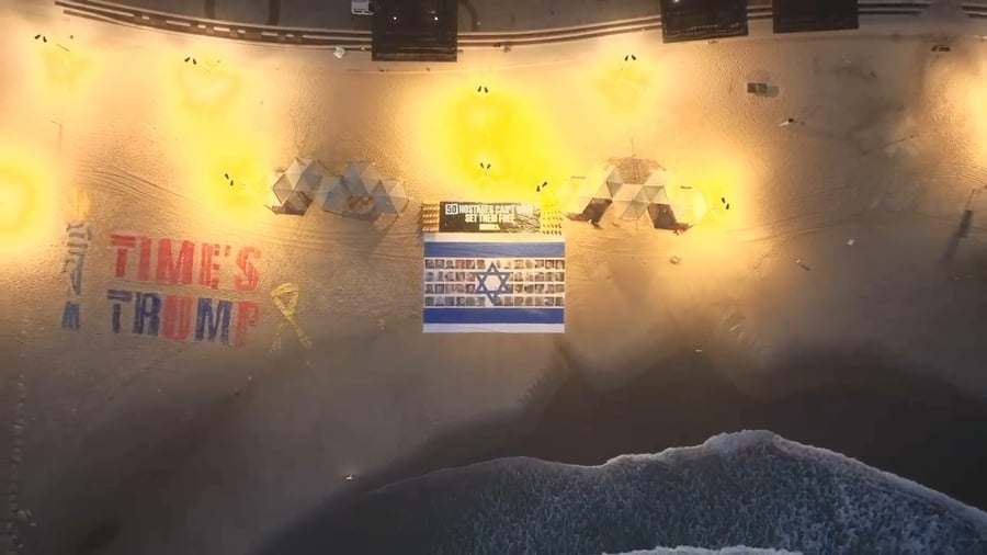 דגל ענק עם תמונות החטופים נפרס מול שגרירות ארצות הברית בתל אביב