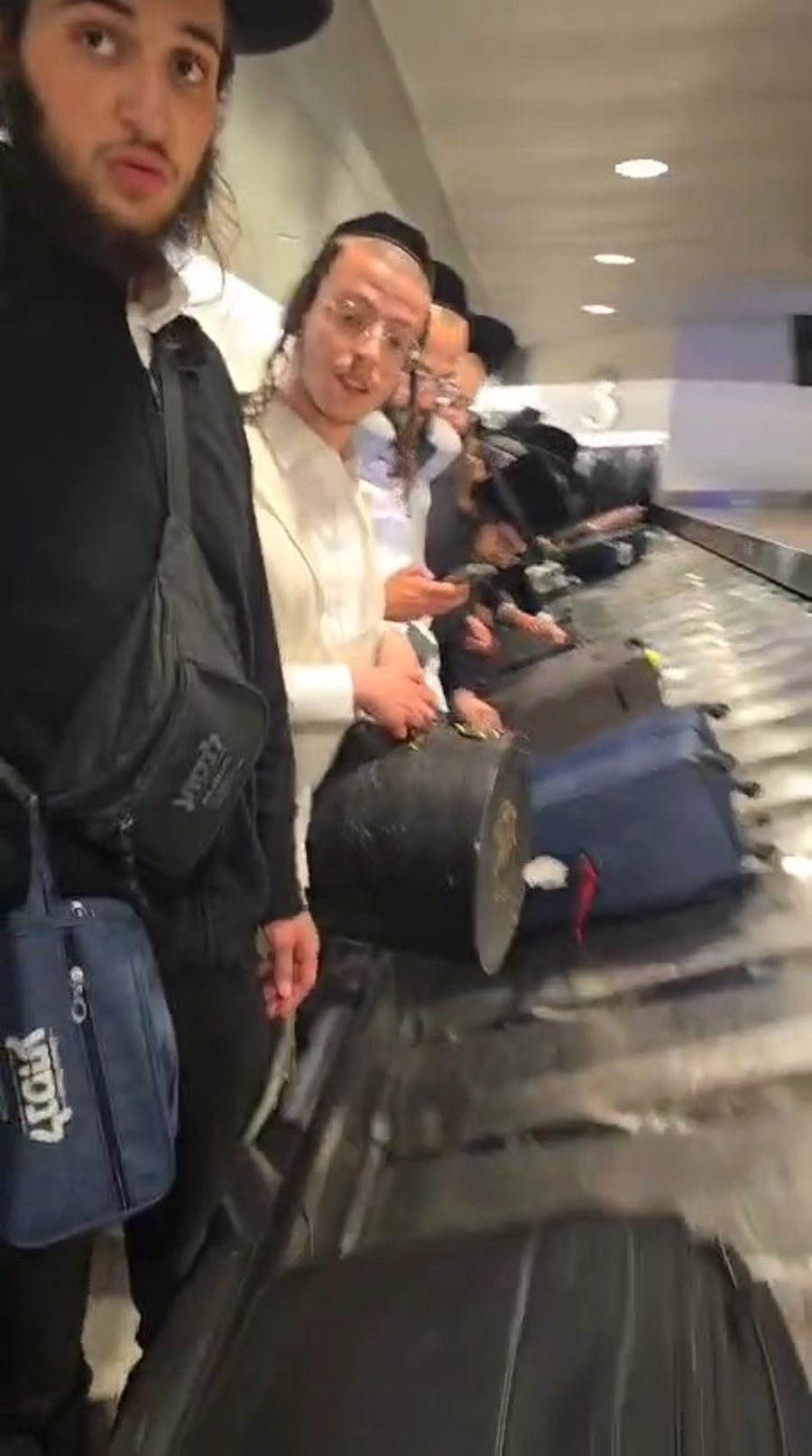החסידים ממתינים לחבילות בשדה התעופה