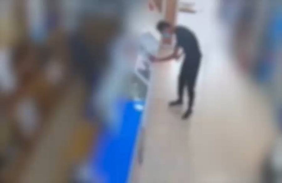 משתמש בכרטיס הגנוב, עם משקפי שמש ומסכה